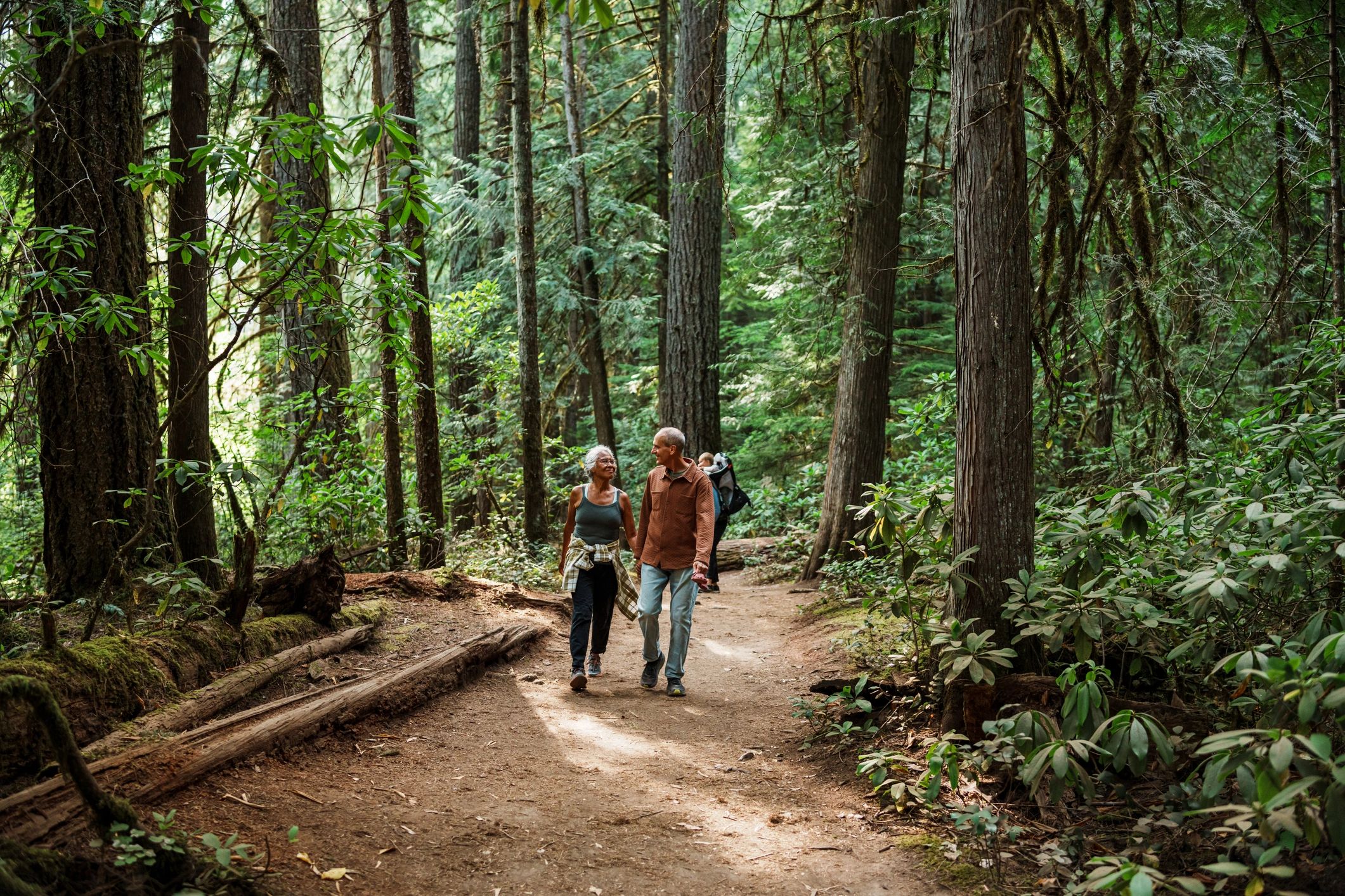Active senior couple hiking together on a forest trail